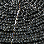 Dessous de verre rond en perles noires motif spirale