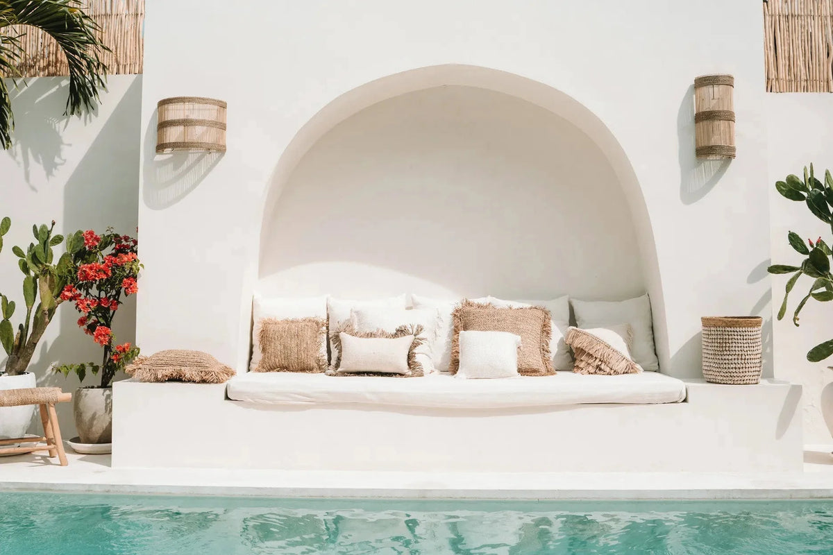 Coin salon extérieur avec coussins en fibres naturelles et coussin blanc