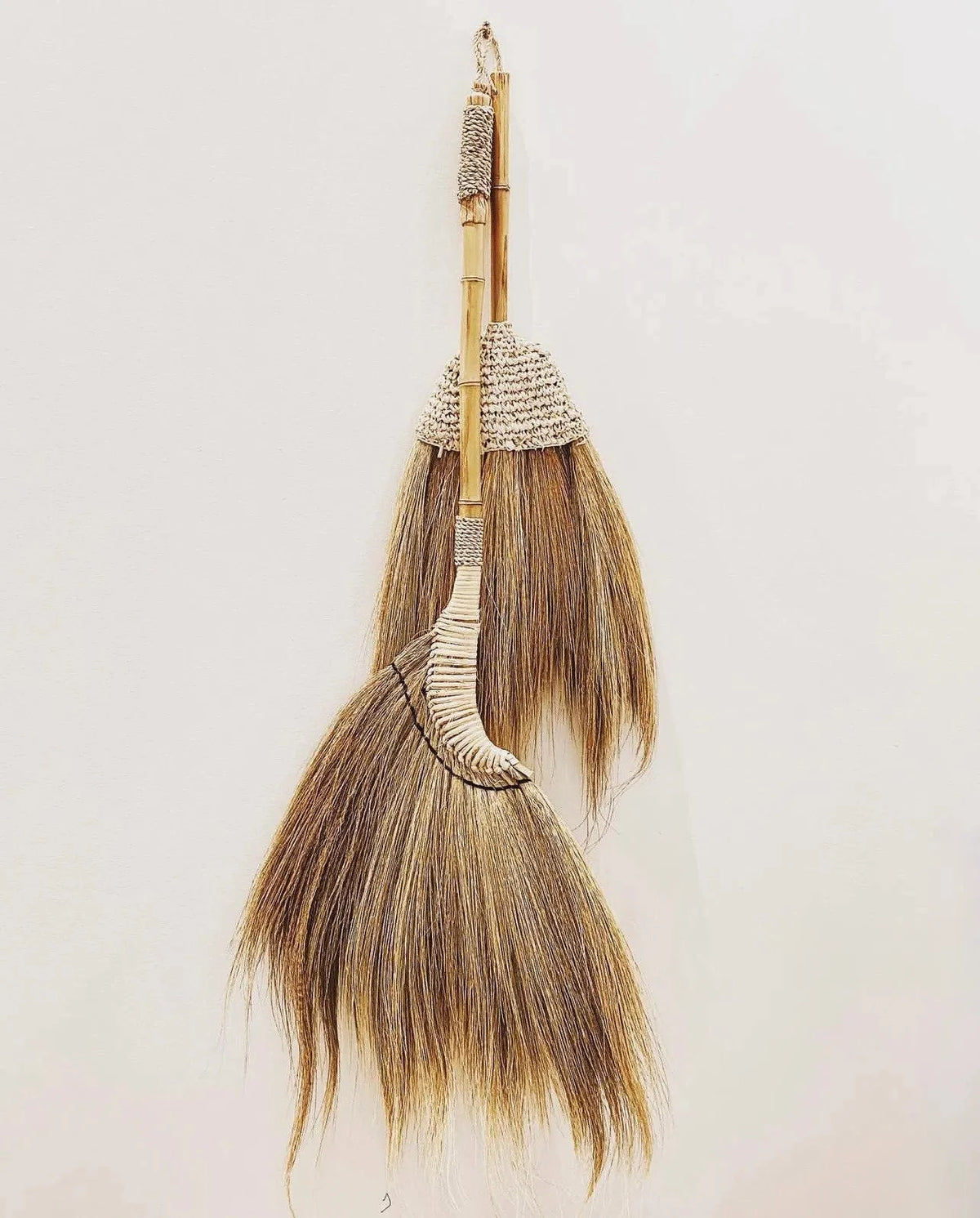 Deux balais décoratifs en fibres naturelles et bambou beige doré