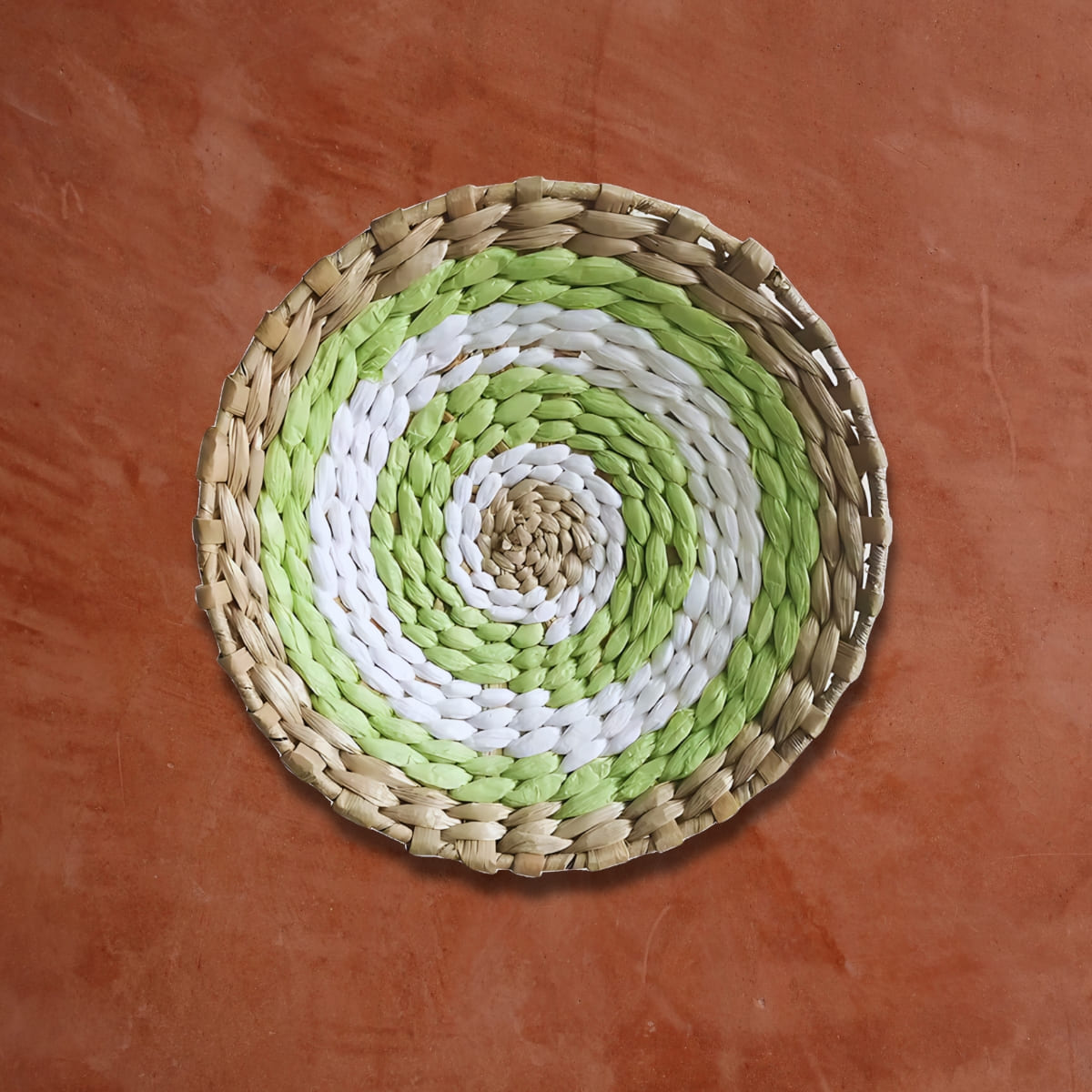 Déco murale en rotin rond vert blanc sur un mur