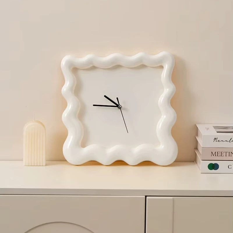 Horloge ondulée blanche posée sur un meuble, décoration minimaliste.