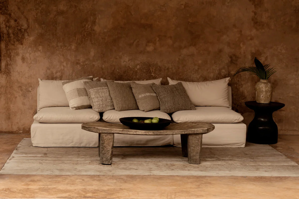 Canapé en lin beige avec coussins à carreaux relief et table basse en bois rustique