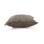 Coussin artisanal en lin tissé noir et beige motif damier sur canapé crème