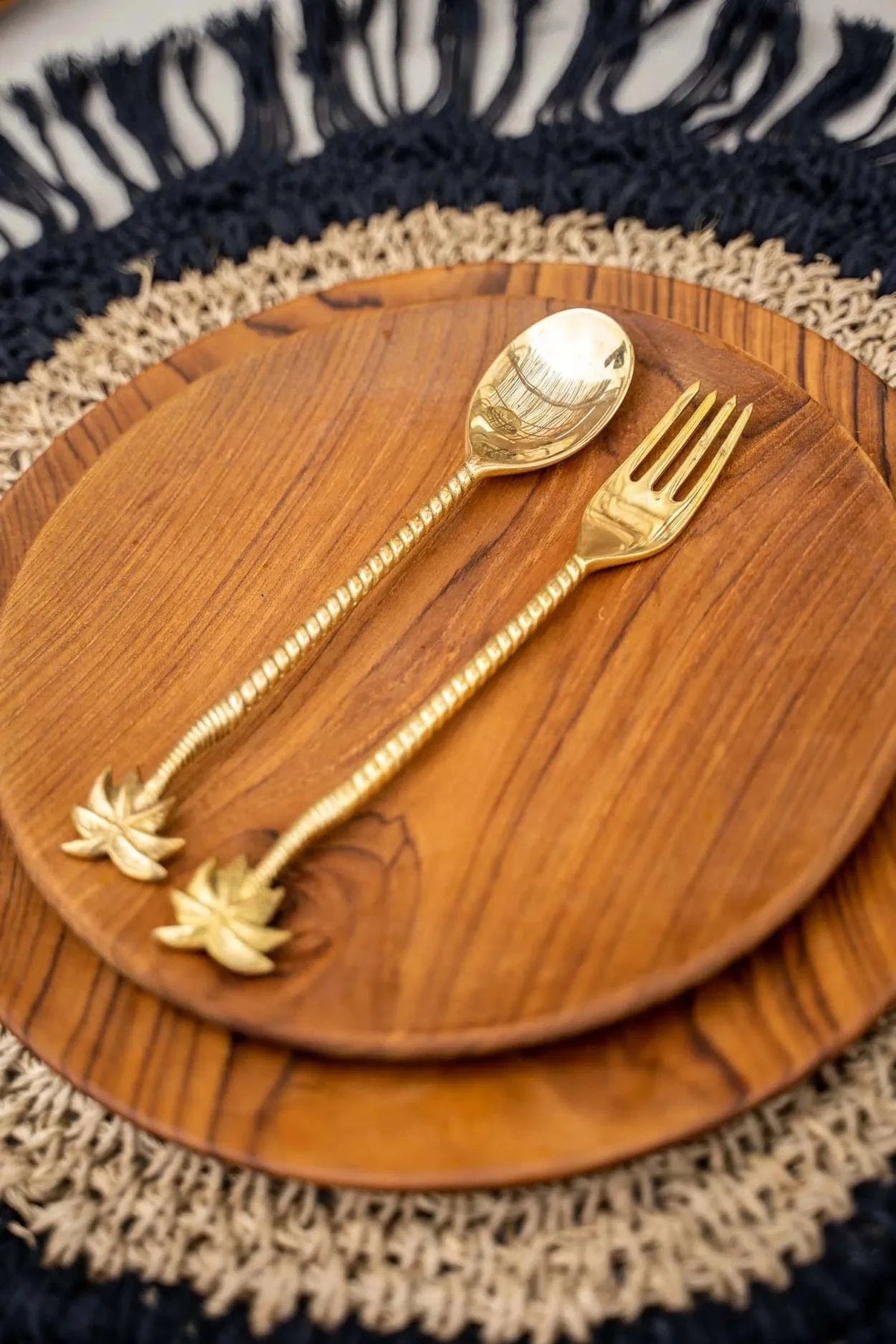 Set de cuillères et fourchettes à poignée en palmier doré sur assiettes en bois naturel
