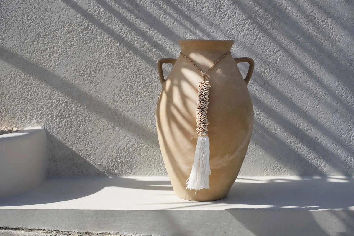Vase en céramique tan avec anses dorées et franges tissées