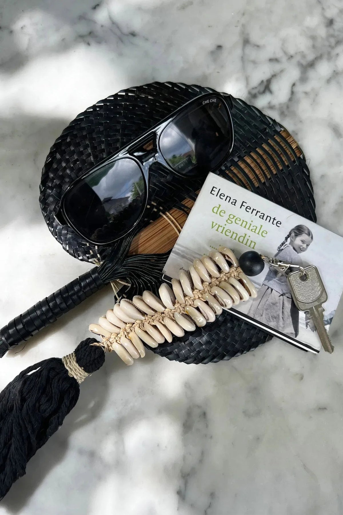 Éventail en paille noire tissée avec pompon et coquillages