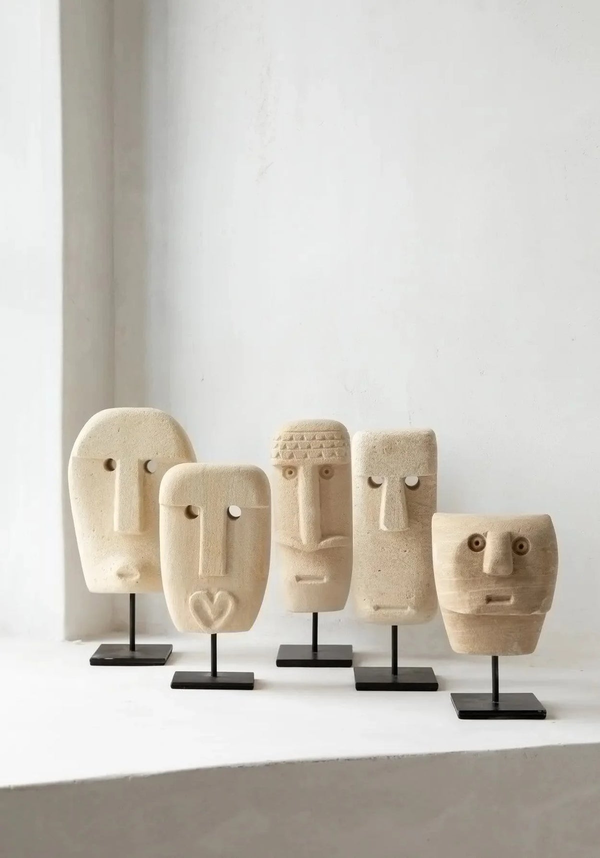 Série de cinq masques abstraits en grès ou bois sur supports noirs pour décoration intérieure
