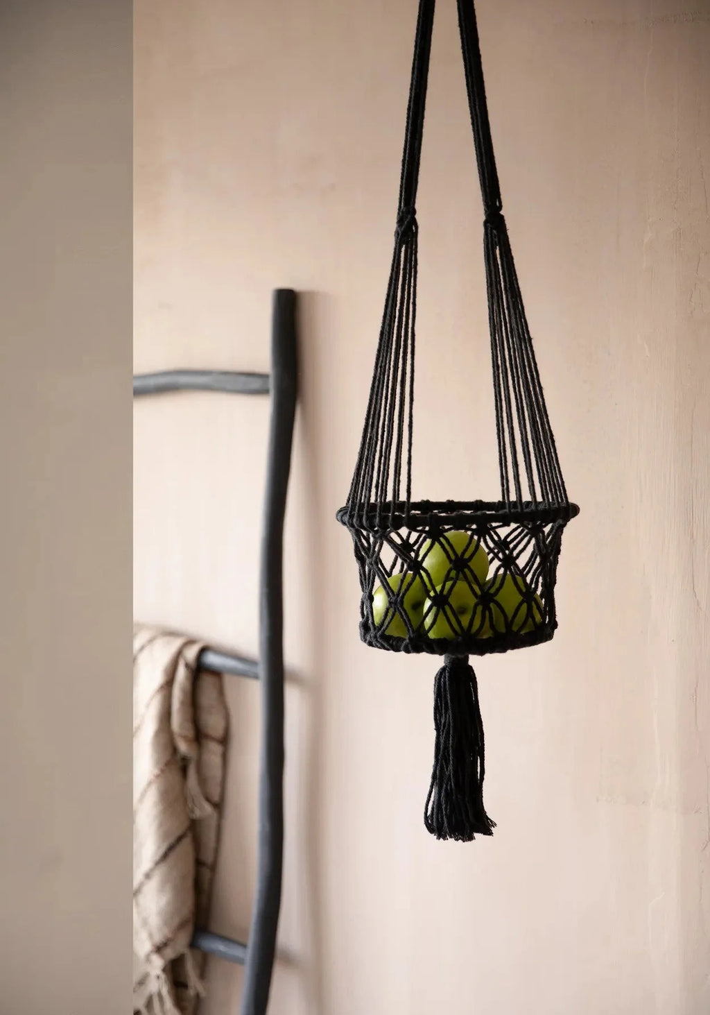 Panier à fruits en macramé noir suspendu avec pommes vertes, Suspension plante macramé en coton noir cylindrique H100 cm