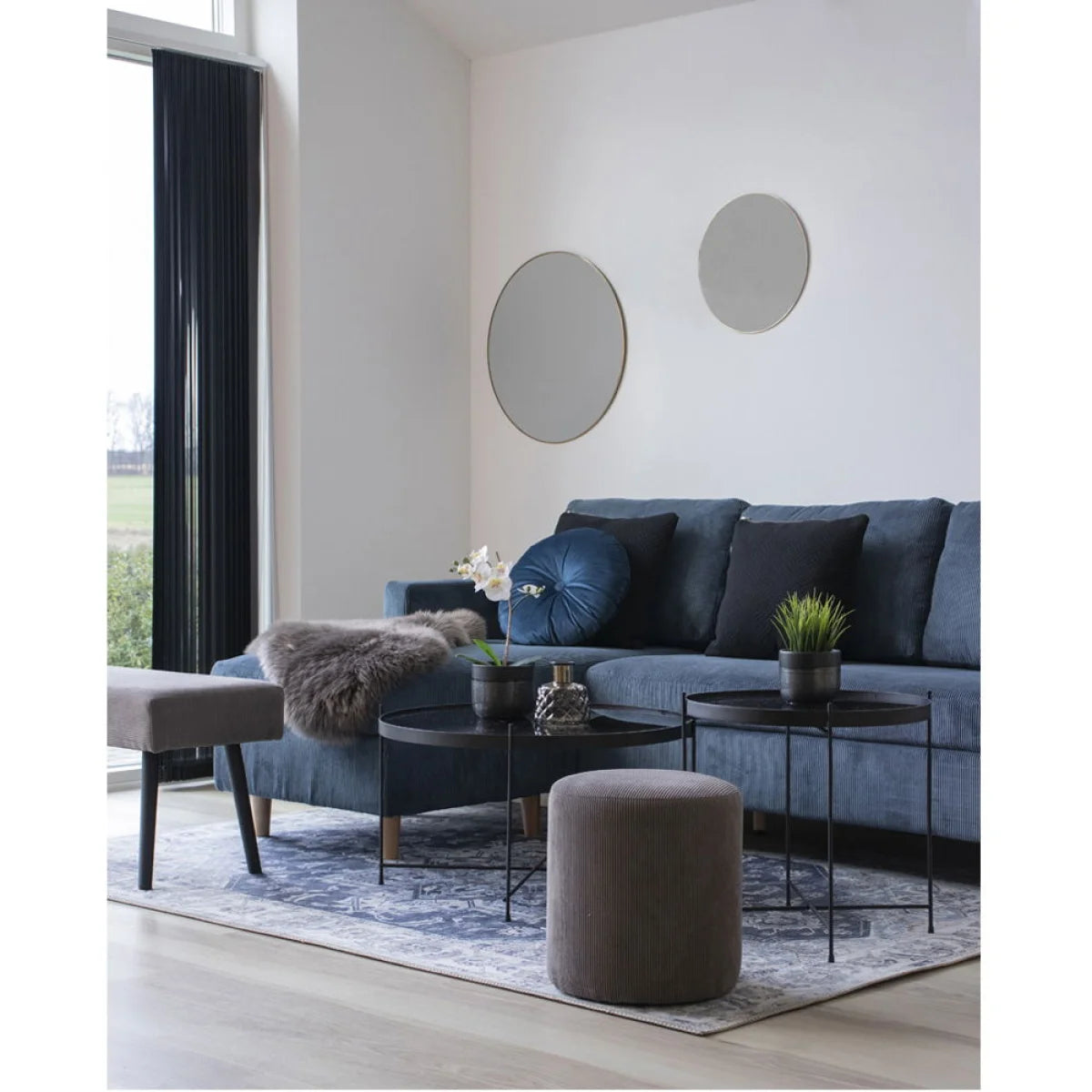 Canapé en velours côtelé bleu avec coussins bleu foncé et coussin rond capitonné