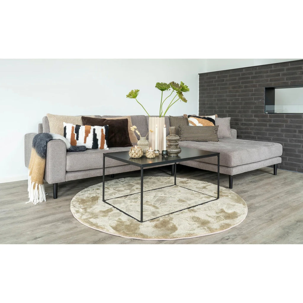 Canapé sectionnel gris avec coussins à motifs et couverture drapée