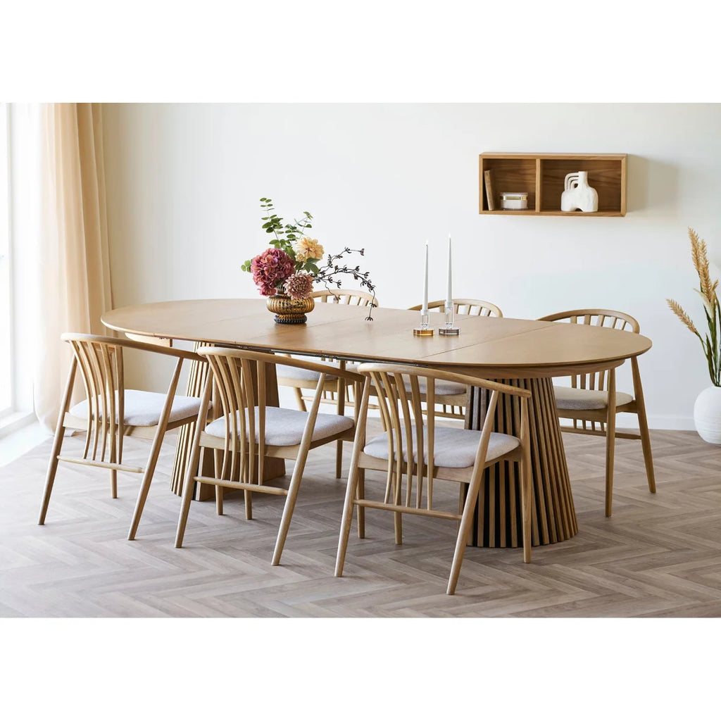 Table ovale en bois clair avec base flûtée et chaises rembourrées blanches