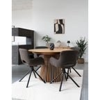 Table ronde en bois avec base ajourée et chaises grises rembourrées